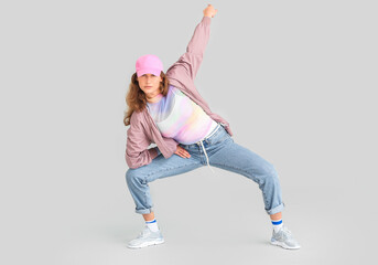 Beautiful female hip-hop dancer on grey background