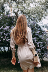 Luxury woman with a lilac flowers. Smile girl in park outdoor.