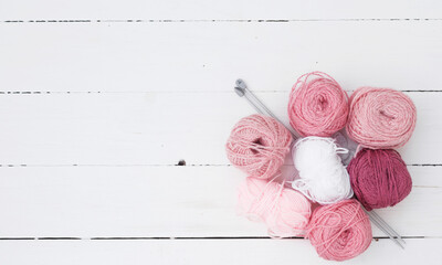 Female hobbies, knitting. Yarn in warm colors. Pink, peach, beige, white and green. Frame made of yarn.