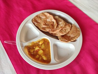Puri and Potato Curry aalu sabji - an indian cuisine in round plate.