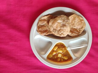 Puri and Potato Curry aalu sabji - an indian cuisine in round plate.