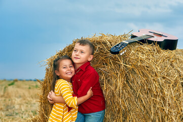 Happy children at the haystack . Happy childhood, brother and sister on a walk