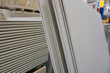 Obraz premium Horizontal and vertical stack of drywall sheets in a store of construction and decoration materials.