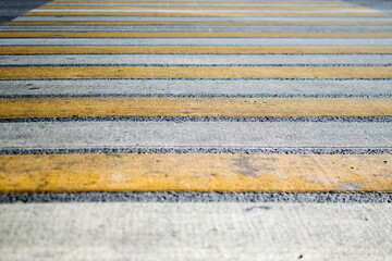 dirty yellow-white pedestrian crossing on a wide road. pedestrian safety on the streets. empty streets .
