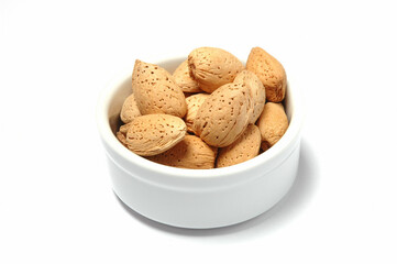 Hazelnuts in bowl against white background