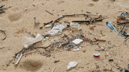 Environmental pollution. Ecological problem. Garbages, plastic, and wastes on the sandy beach of tropical sea.