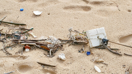 Obraz premium Environmental pollution. Ecological problem. Garbages, plastic, and wastes on the sandy beach of tropical sea.