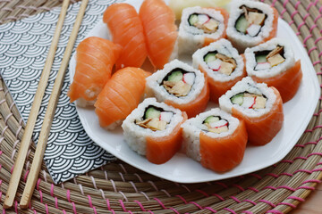 Sushi California rolls with ginger and chopsticks on a plate on wooden table. Delicoius Sushi food