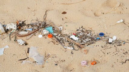 Environmental pollution. Ecological problem. Garbages, plastic, and wastes on the sandy beach of tropical sea.