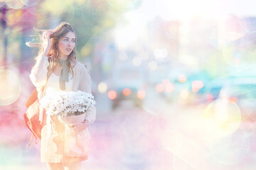 happy girl with flowers in the city / summer photo young beautiful girl holding a bouquet of flowers on a city street