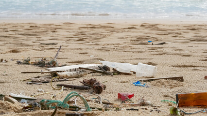 Environmental pollution. Ecological problem. Garbages, plastic, and wastes on the sandy beach of tropical sea.
