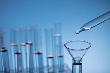 Coronavirus pandemic theme. Science research concerning fast covid tests and anti-covid vaccine. Beakers and test tubes on blue background.