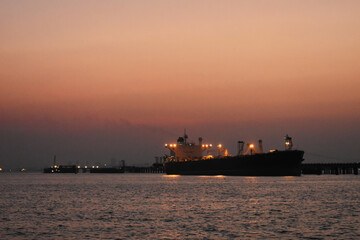 A merchant ship standing near the Port of Mumbai, captured in evening.