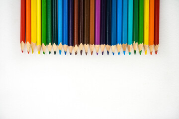 Many rainbow color pencils isolated on white background