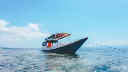 Boat resting on calm sea water with blue sky