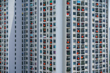 Fototapeta na wymiar Modern apartment building with a lot of Vietnamese flags hanging on windows during importance special days in Hanoi, Vietnam