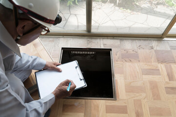 床下点検口から基礎を調査するビジネスマン