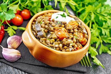 Lentils with eggplant and tomatoes in bowl on table