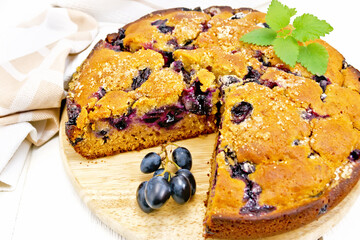 Pie with black grapes on light board