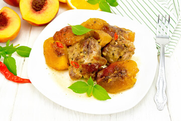 Turkey with peaches in plate on wooden board