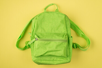 Back to school concept. Top above overhead view photo of green backpack isolated on yellow...