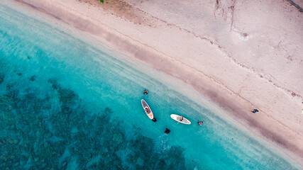 Aerial drone birds eye view of tourists canoeing in tropical beach of Moyo Island, Sumbawa, Indonesia