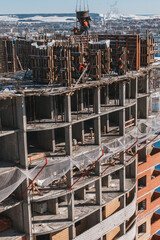 The course of construction of a multi-storey building. Ready-made floors, balconies, empty floors, mesh, fittings. Vertical orientation.