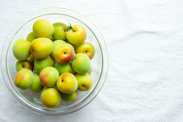 調理するためにガラスのボールに入った収穫した熟した梅の実