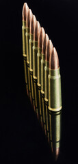 metal cartridges for hunting automatic weapons on a black background with a reflection
