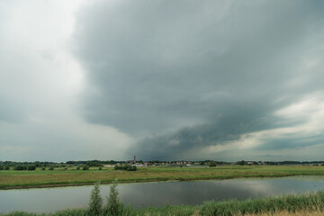 Thunderstorm over dutch river landscape