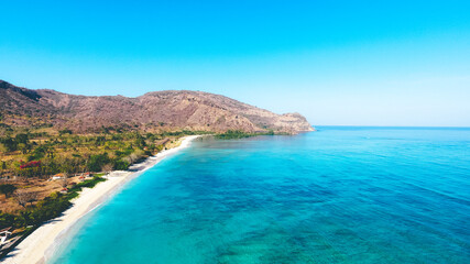 Aerial drone view of an empty white sandy beach in tropical Jelenga Beach in West Sumbawa, Indonesia