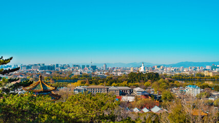 Amazing view of Beijing city from the observation deck in Jingshan Park. View of Beihai Park and White Pagoda. Asia, China, Beijing. Stunning cityscape. Sunny day, clear blue sky. Panorama view.