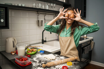 Young african-american woman is making cookies in her kitchen.