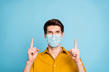 Close-up portrait of his he nice healthy guy wearing safety mask pointing up copy space information...