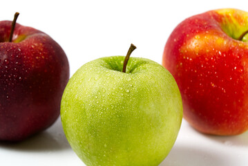 Three apples with water drops. Delicious appetizing beautiful fresh green and red apples on a white background.