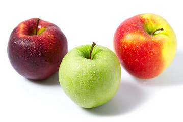 Three apples with water drops. Delicious appetizing beautiful fresh green and red apples on a white background.