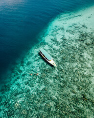 Aerial view of snorkeling boats with people snorkeling and enjoy the underwater view of Gili Trawangan Waters in Gili Island, Lombok, Indonesia