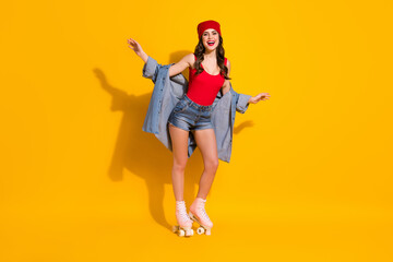 Fototapeta na wymiar Full size photo of candid pretty fit sporty youth girl enjoy riding pink skates wear red headwear jeans tank-top isolated over bright color background