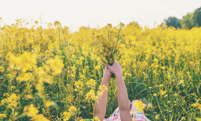 A child in a yellow field, mustard blooms. Selective focus.