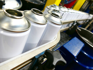 empty steel aerosol cans on production line in factory