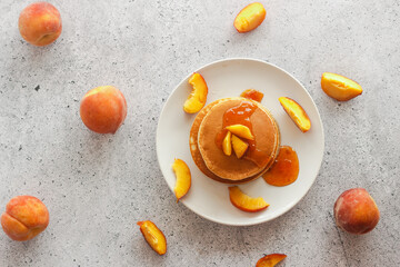 Pancakes with apricot jam and peaches. Pancakes on a plate. Tasty breakfast