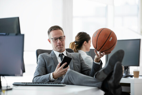 Colleagues In Office. Handsome Businessman With Basketball In Office.	