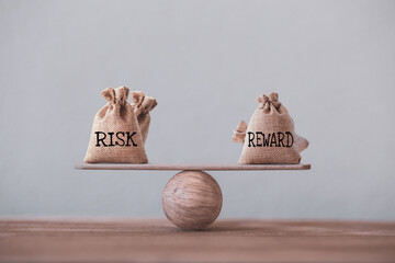 Risk and reward bags on a basic balance scale in equal position. risk management concept, depicts...