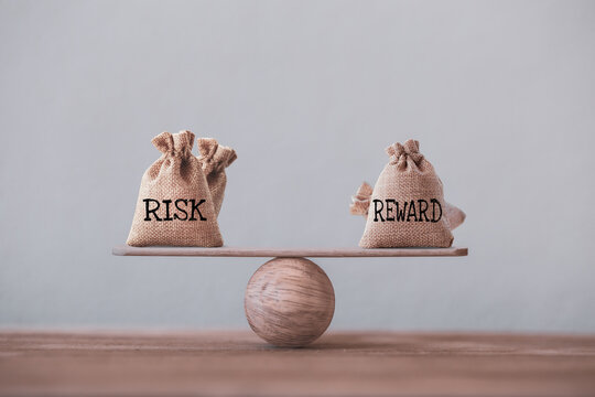 Risk and reward bags on a basic balance scale in equal position. risk management concept, depicts investors use a risk reward ratio to compare the expected return of an investment