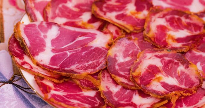 Cibo in Calabria, capocollo affettato tipico calabrese in un piatto.