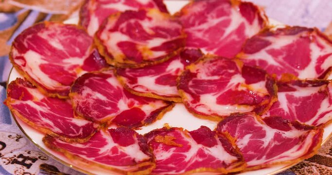 Cibo in Calabria, capocollo affettato tipico calabrese in un piatto.