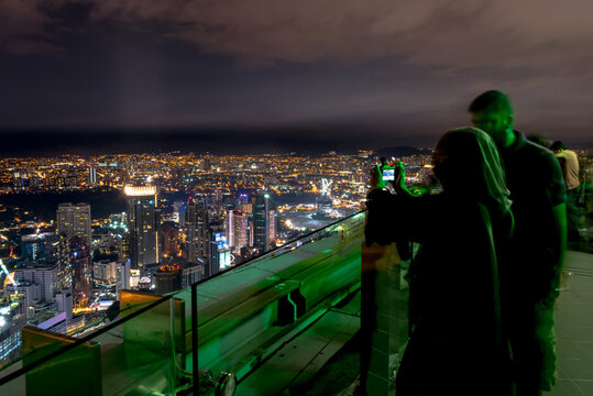 Kuala Lumpur, Federal Territory / Malaysia - February 25, 2017: Long shutter capture of tourists taking photo of city view at skydeck of Kuala Lumpur Tower at night.