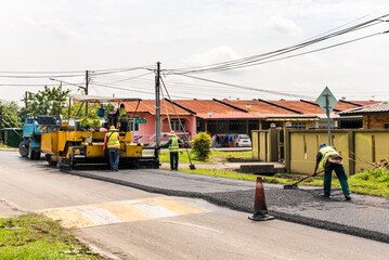 Kuching, Sarawak / Malaysia - September 22, 2018: Worker clears up asphalt during road repairing in...