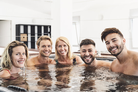 Happy Friends Enjoying Vacations In Jacuzzi Luxury House - Young People Having Fun Together In Hot Tub - Youth Millennial Generation And Wellness Lifestyle Holidays