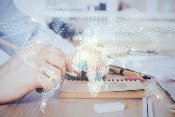 Double exposure of hands and notepad with business icons.